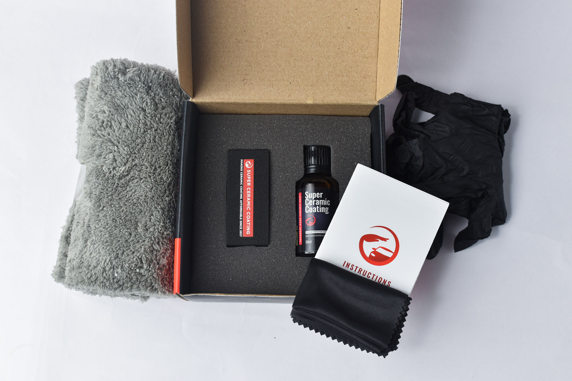 Super Ceramic Coating DIY Kit contents with coating bottle, applicator, microfiber cloth, gloves, and instructions